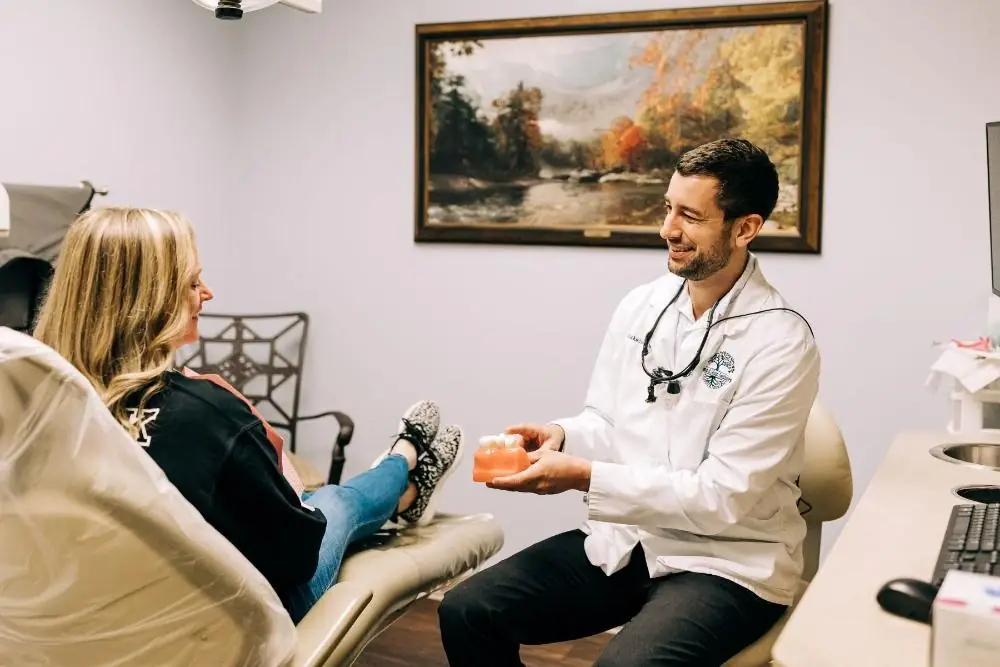 Dr. Blake Nelson showing a patient a model of the teeth in a treatment room at his Winston-Salem office.